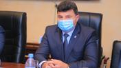 Виктор Ионенко сидит в маске за столом